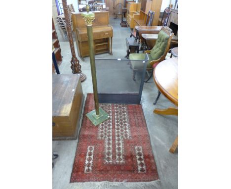 An onyx and brass standard lamp, small red rug and a brass and pierced steel spark guard