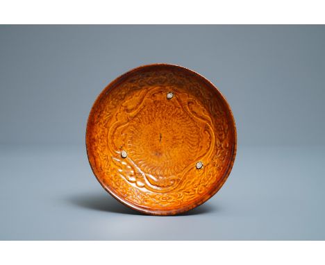 A Chinese amber-glazed relief-decorated saucer dish, Liao (916-1125) -- Dia.: 13,5 cmÊ Provenance: The collection of Dr. Pete