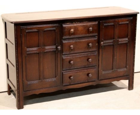 An Ercol sideboard with 4 drawers flanked by 2 cupboards (147 x 52 x 91 cm h)