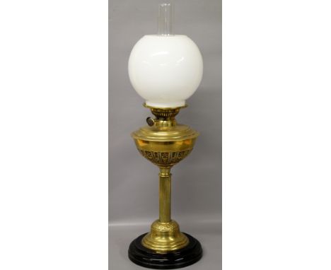A Victorian oil lamp of column form with decorative brass reservoir