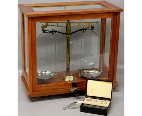 A set of early 20th Century laboratory balance scales housed in original glazed cabinet with boxed weights - Griffin & George