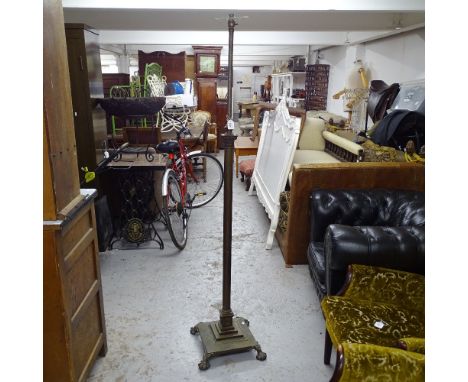 An Antique fluted brass telescopic standard lamp, on stepped plinth base and lion paw feet 