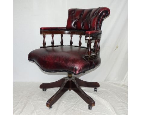 A red leather button-back upholstered swivel desk chair 