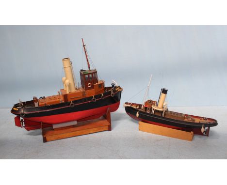 Two scratch built motorised model tug boats sitting upon stands, one lacking motor and named 'Dolphin, London' largest measur