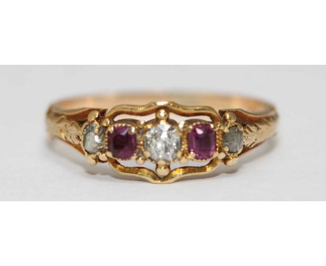 An early 20th century unmarked gold, diamond and ruby ring, central cushion cut diamond flanked by two rubies and a further t