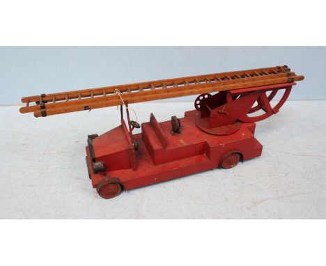 A mid 20th century large wooden toy fire engine with adjustable ladder on revolving rig, black number plate to front reads 'G
