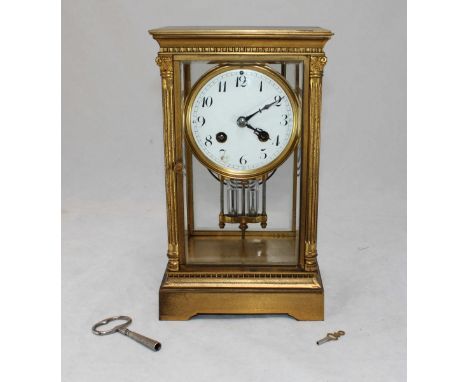 An Edwardian French gilt mantel clock, the white enamel dial with Arabic numerals denoting hours, glazed front panel flanked 