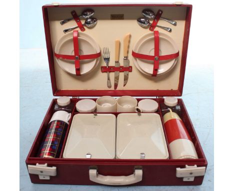 A 1950's Brexton picnic set for four people, including two Thermos flasks, two tin food boxes, tea cups and much more, all in