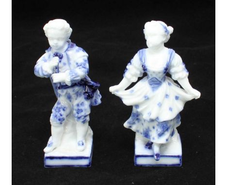 A pair of blue and white painted German porcelain figures (possibly Dresden) depicting a boy playing a clarinet and a girl da