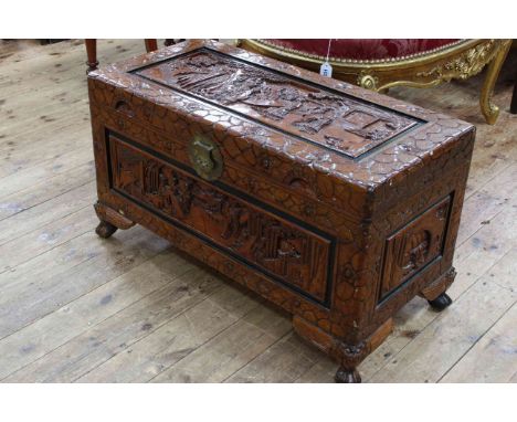Oriental carved camphorwood trunk on claw feet, 49cm by 86cm by 41cm.