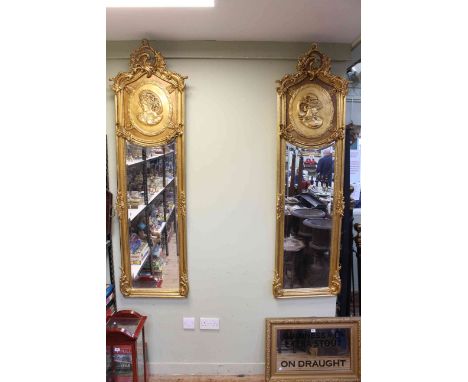 Pair rectangular gilt framed portrait bevelled wall mirrors with ornate swag and floral crests, 179cm by 53cm.