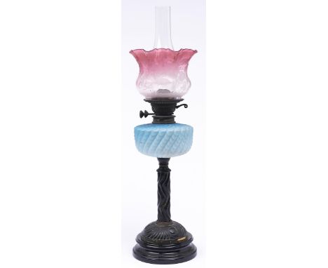 A Victorian brass oil lamp,&nbsp; with blue satin glass fount, brass burner and etched and shaded cranberry glass shade, on b