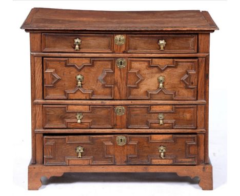 A William III geometric moulded oak chest of drawers, with brass axe head handles and escutcheons, the sides panelled, 89cm h