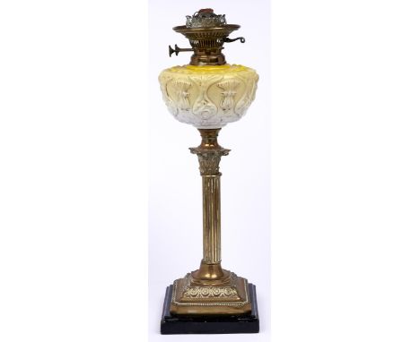 An Edwardian brass Corinthian column oil lamp, with press moulded and gilt yellow glass fount and brass burner, black glazed 