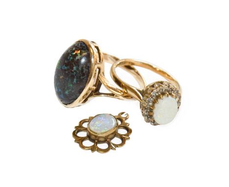 A 9 carat gold opal and diamond cluster ring, finger size K1/2 (a.f.); a black opal ring, unmarked, finger size M (a.f.); and