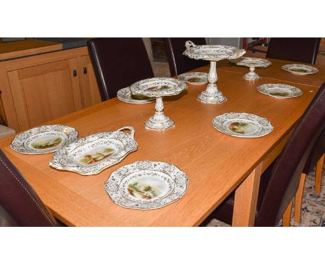 An English porcelain dessert service, painted with romantic landscapes under wide gilt borders, circa 1830, comprising three 