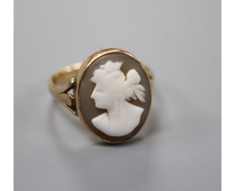 An early 20th century 15ct and oval cameo shell set dress ring, carved with the bust of a lady to dexter, size P, gross 4.2 g