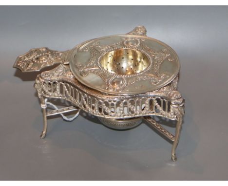 An ornate late 19th century German white metal tea strainer on tripod stand, height 69mm, 6.5 oz.CONDITION: Handle split near