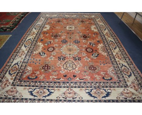 A large Persian pink ground carpet, woven with medallions and stylised flowers and leaves, approx. 410 x 290cm