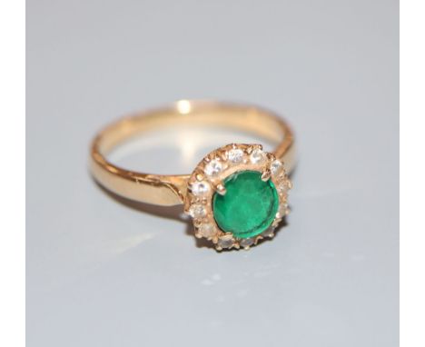 A yellow metal, emerald and diamond circular cluster ring, size L/M, gross 3.1 grams.CONDITION: Would benefit from a good cle