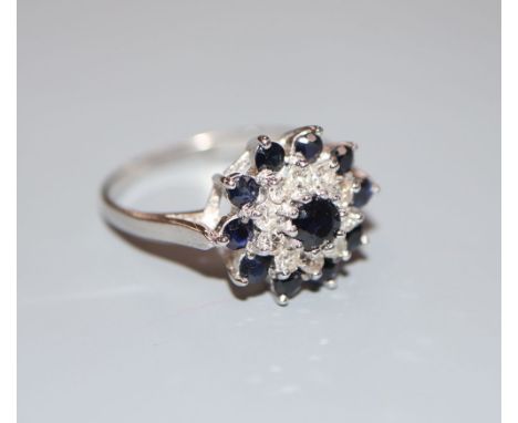 A modern 18ct white gold, sapphire and diamond cluster ring, size S, gross 4.7 grams.CONDITION: Overall condition is good.