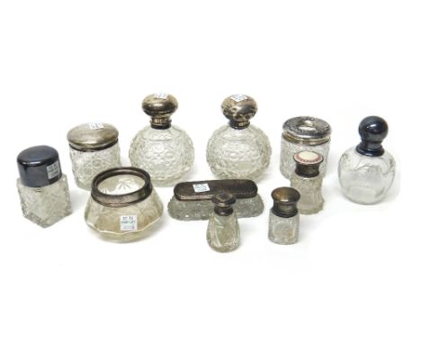 A silver topped faceted glass scent bottle, Chester 1921, a silver topped faceted glass hair tidy jar, Chester 1908, a silver