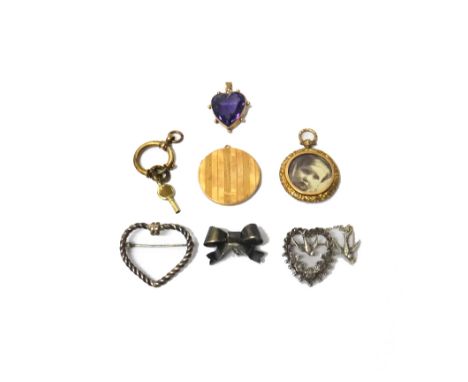 A gold and amethyst set single stone pendant, mounted with a heart shaped amethyst, within a beaded surround, detailed 9 C, a