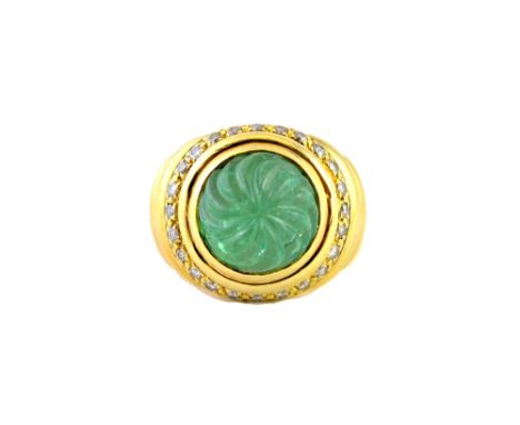 A gold, carved emerald and diamond set ring, detailed Tambetti 18 K, the circular emerald carved in a spiral design, within a