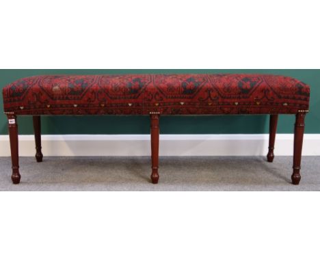 A large rectangular footstool with carpet upholstered seat, on six turned mahogany supports, 155cm wide.