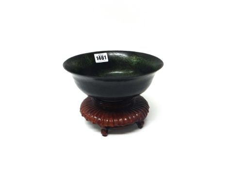 A spinach jade bowl, 20th century, with everted rim, 19cm.diameter, wood stand.