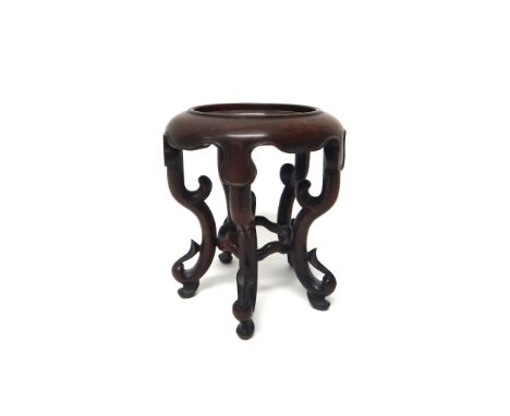 A Chinese hardwood vase stand, with circular dished top, shaped apron and four scroll supports, 20.5cm.high.