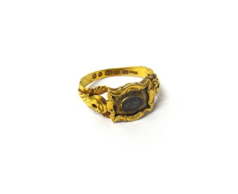 A Victorian 18ct gold mourning ring, the centre mounted with an oval glazed hair locket, within a rectangular surround, havin