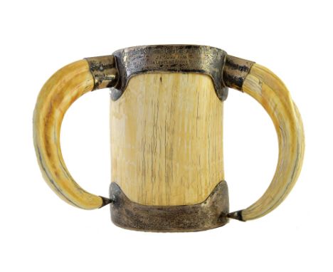 A large Victorian silver mounted ivory cup, London 1884, of cylindrical form with tusk handles and presentation engraved rim,