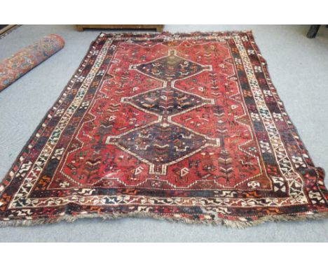 A Shiraz carpet, South Persian, the madder field with three diamonds, all with birds and flowers, various borders, 250cm x 18