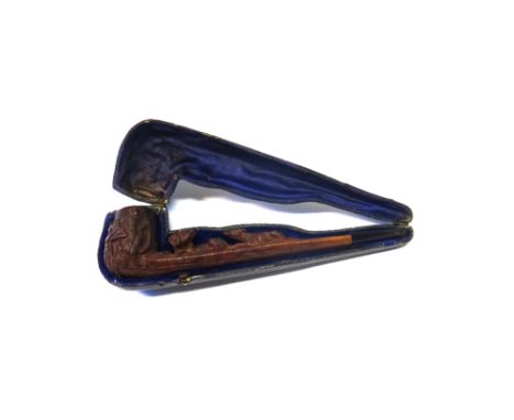 A Black Forest carved wooden pipe, late 19th century, detailed to the shaft with a fox and hound, and hunting paraphernalia t