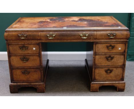 An 18th century style walnut pedestal desk with nine drawers about the knee, on bracket feet, 138cm wide. 