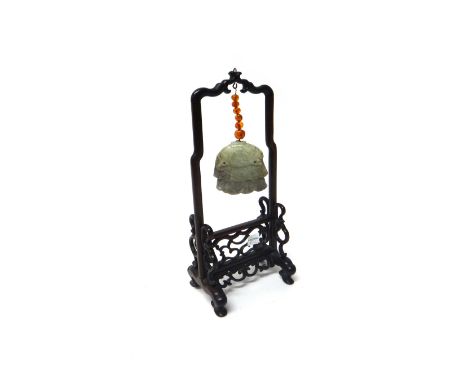 A Chinese celadon jade pendant, Ming Dynasty, carved as a three tier canopy suspended by a wire strung with six amber beads f