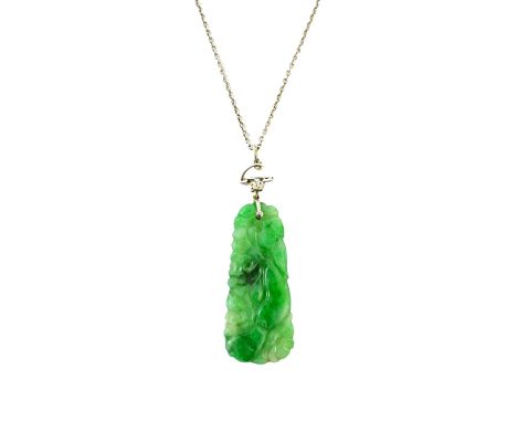 A carved jade pendant, in a tapering panel shaped design, decorated with fruit and foliage and with a rose diamond and seed p