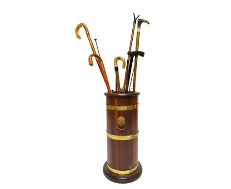 A 19th century brass bound coopered mahogany circular stick stand, with lion ring handles, on a stepped base, 65cm high.  Ill