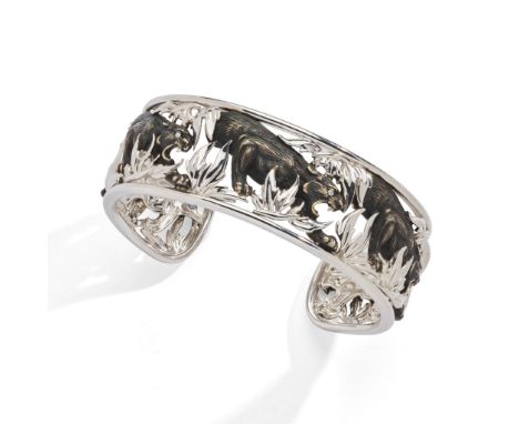 A diamond-set bangle The openwork torc of bi-coloured design, modelled as prowling panthers with brilliant-cut diamond eyes, 