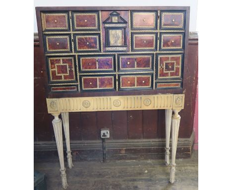 A 17th century continental, probably Italian, tortoiseshell and ivory cabinet, having a central arcaded top drawer, inset wit