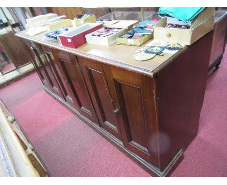 A mahogany counter, having three pairs of two fielded panel doors to the front, raised on a plinth base, width 80ins x depth 