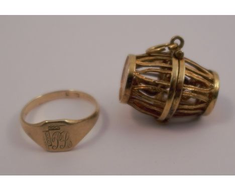 A 9 carat gold signet ring, and a charm of a drinking man trapped in a cage barrel, 9.4g gross