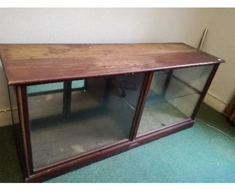 A 19th century mirror back counter unit, having a glazed front, and four doors opening to the reverse, with a glazed shelf to