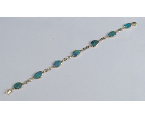 An opal doublet bracelet, stamped '14k' over '585', the seven doublets with figure of 8 links between, 19cm long, 10g gross