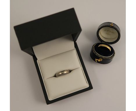 An unmarked white metal wedding ring, together with a 9 carat gold wedding ring, 7g gross