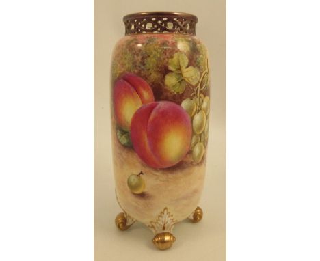 A Royal Worcester spill vase, decorated half round with fruit by Freeman, having a pierced gilt neck and raised on four gilt 