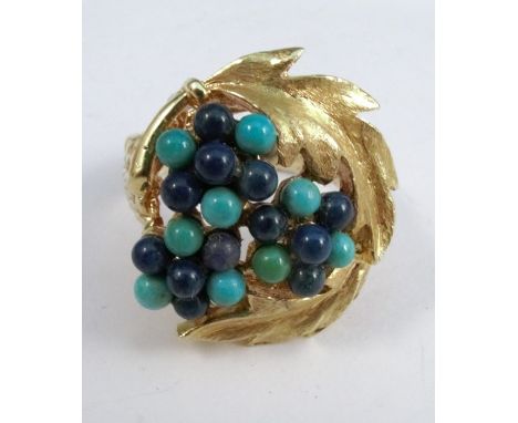 A turquoise and sodalite bead set ring, engraved '750', the beads enclosed by two leaf motifs, finger size Q, 13.4g gross