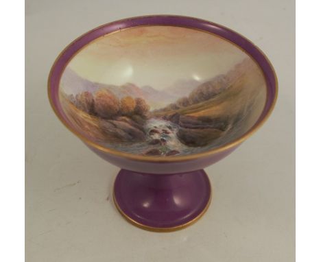 A Royal Worcester standing cup decorated to the interior with a waterfall in landscape by R Rushton, with purple outer and pe