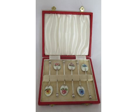 A cased set of six silver and enamel coffee spoons, the back of each bowl decorated with a different flower to a white ground
